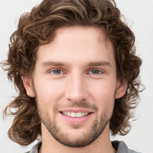 Joyful white young-adult male with short  brown hair and green eyes