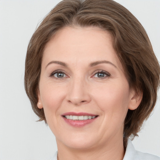 Joyful white adult female with medium  brown hair and grey eyes