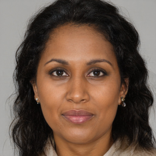 Joyful black adult female with long  brown hair and brown eyes