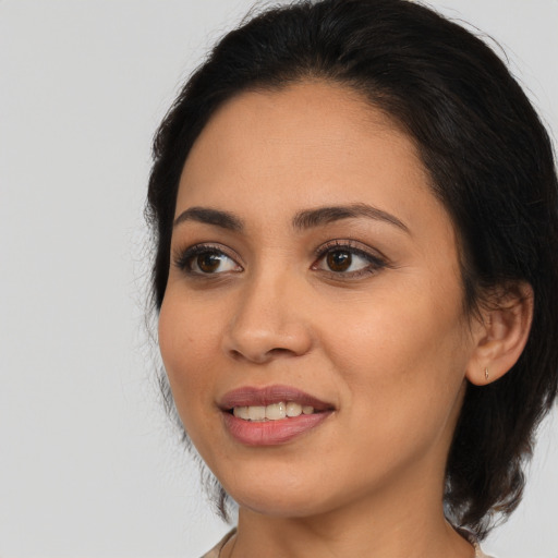Joyful latino young-adult female with medium  black hair and brown eyes