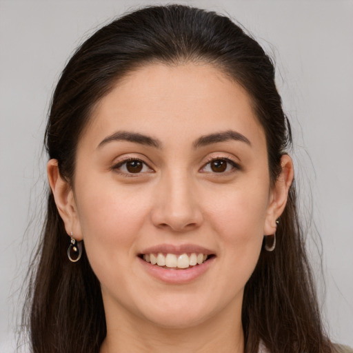 Joyful white young-adult female with long  brown hair and brown eyes