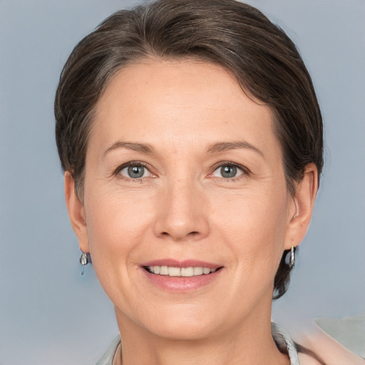 Joyful white adult female with medium  brown hair and grey eyes