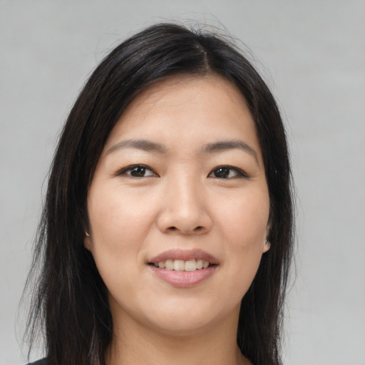 Joyful asian young-adult female with long  brown hair and brown eyes