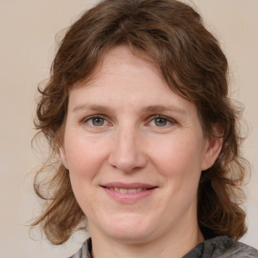 Joyful white adult female with medium  brown hair and blue eyes