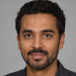 Joyful latino young-adult male with short  black hair and brown eyes