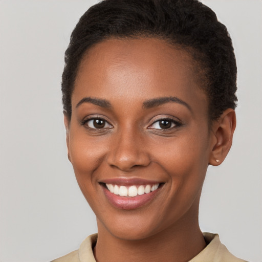 Joyful black young-adult female with short  brown hair and brown eyes