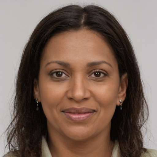 Joyful black adult female with long  brown hair and brown eyes