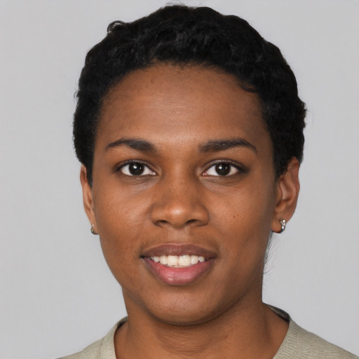 Joyful black young-adult female with short  black hair and brown eyes