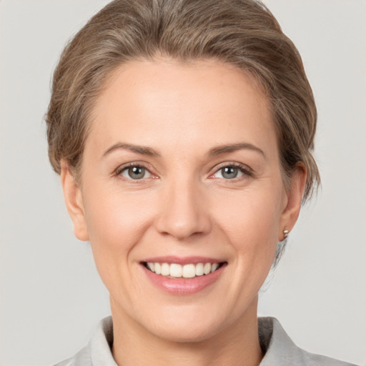 Joyful white young-adult female with short  brown hair and grey eyes