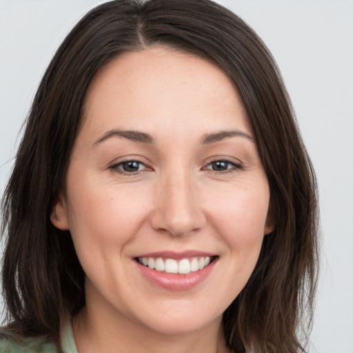 Joyful white young-adult female with long  brown hair and brown eyes