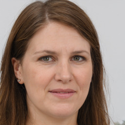 Joyful white adult female with long  brown hair and grey eyes