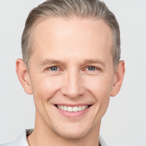 Joyful white adult male with short  brown hair and grey eyes