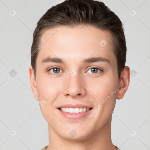 Joyful white young-adult male with short  brown hair and grey eyes