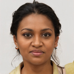 Joyful black young-adult female with medium  brown hair and brown eyes