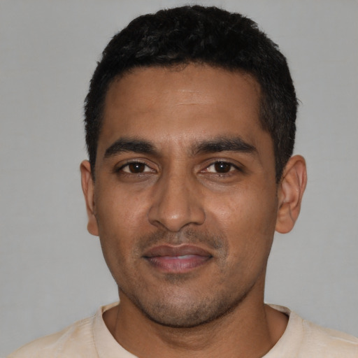 Joyful latino young-adult male with short  black hair and brown eyes