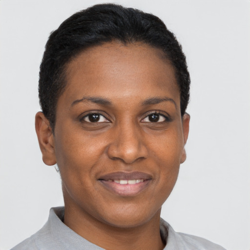 Joyful black young-adult female with short  black hair and brown eyes