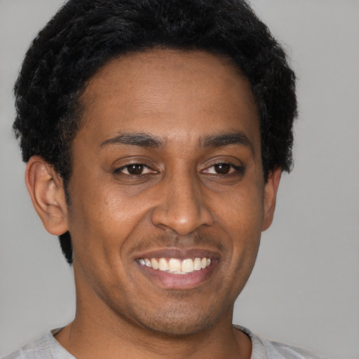 Joyful latino young-adult male with short  brown hair and brown eyes