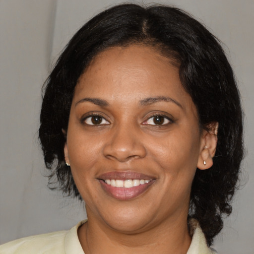 Joyful black young-adult female with medium  brown hair and brown eyes