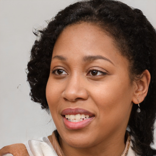 Joyful black adult female with medium  brown hair and brown eyes