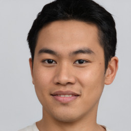 Joyful asian young-adult male with short  brown hair and brown eyes