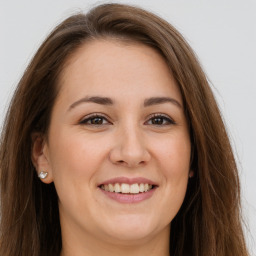 Joyful white young-adult female with long  brown hair and brown eyes