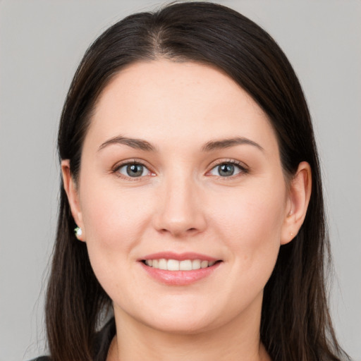 Joyful white young-adult female with long  brown hair and brown eyes