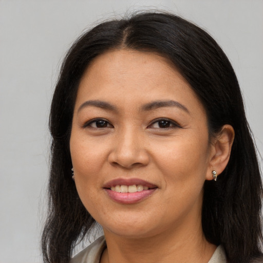 Joyful asian adult female with long  brown hair and brown eyes