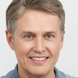 Joyful white adult male with short  brown hair and grey eyes