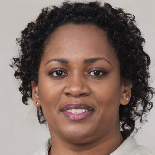 Joyful black adult female with short  brown hair and brown eyes