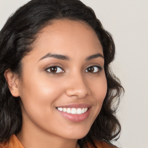 Joyful latino young-adult female with long  brown hair and brown eyes