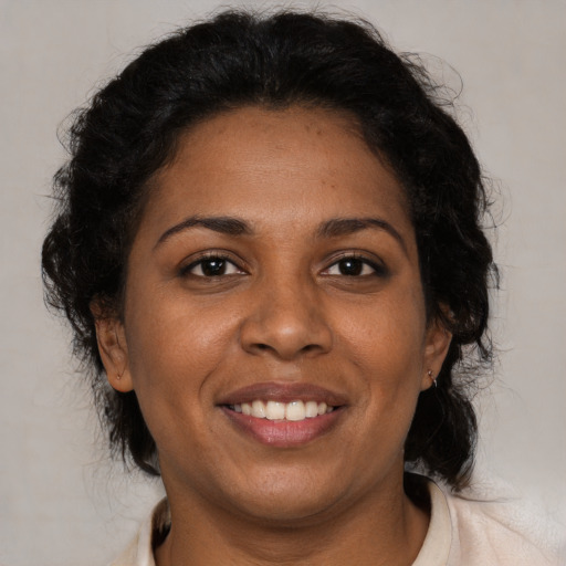 Joyful black adult female with medium  brown hair and brown eyes