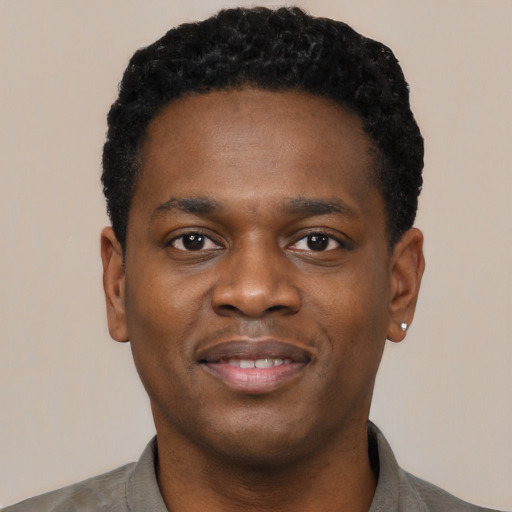 Joyful black young-adult male with short  black hair and brown eyes