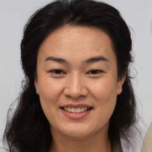 Joyful asian adult female with medium  brown hair and brown eyes
