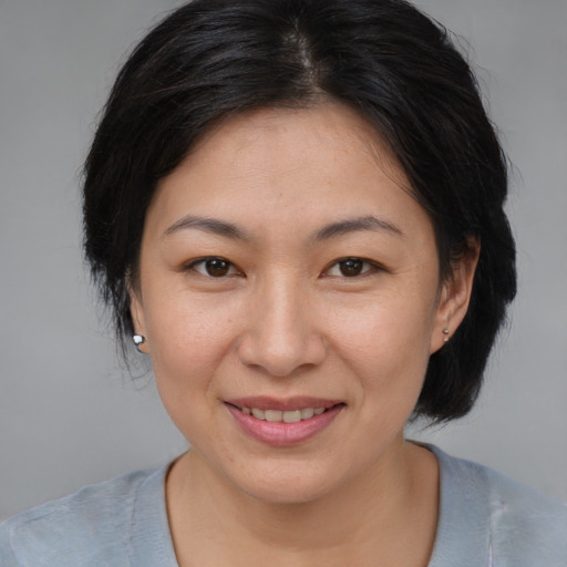 Joyful asian adult female with medium  brown hair and brown eyes