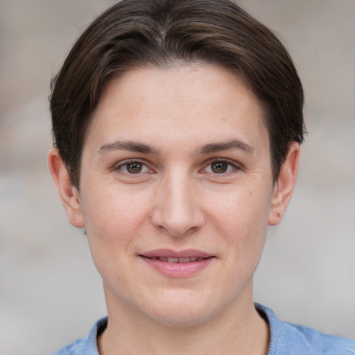 Joyful white young-adult female with short  brown hair and grey eyes