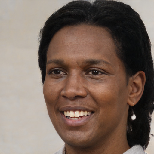 Joyful black adult female with medium  black hair and brown eyes