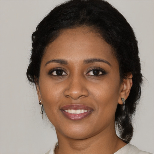 Joyful black young-adult female with medium  black hair and brown eyes