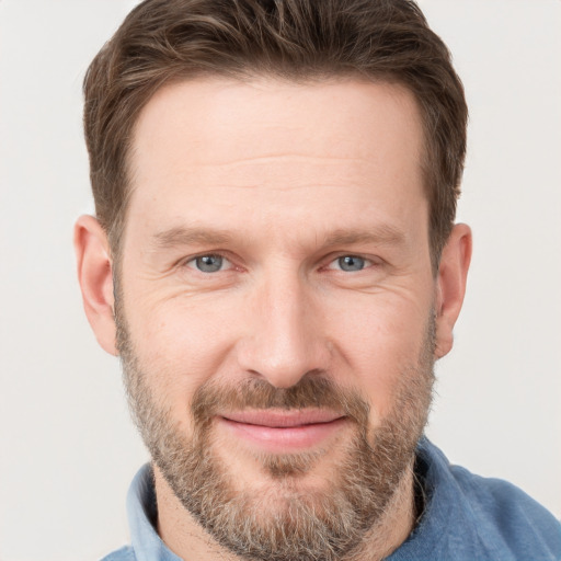 Joyful white adult male with short  brown hair and grey eyes