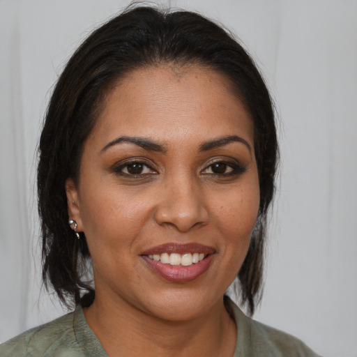 Joyful black young-adult female with medium  brown hair and brown eyes