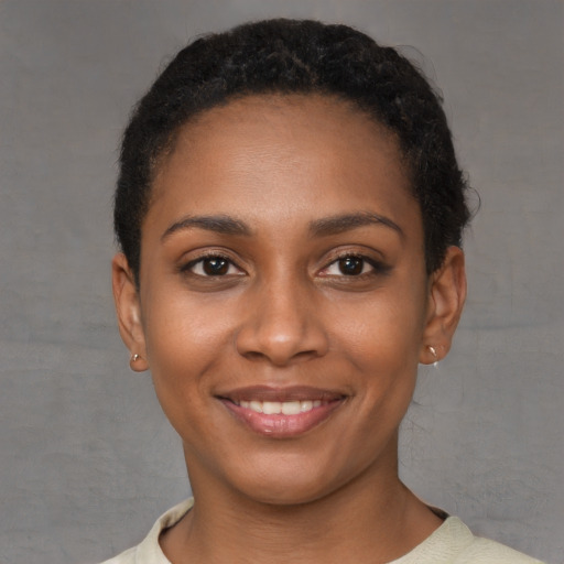 Joyful black young-adult female with short  brown hair and brown eyes