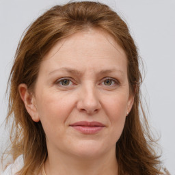 Joyful white adult female with long  brown hair and grey eyes