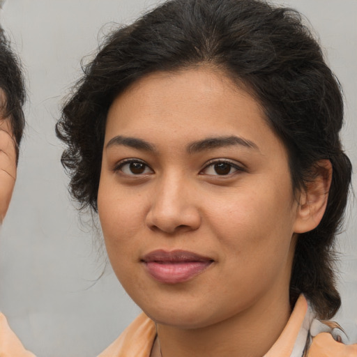 Joyful latino young-adult female with medium  brown hair and brown eyes