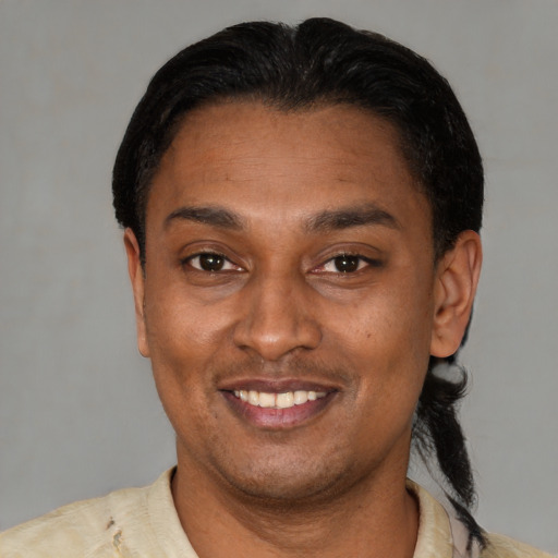 Joyful latino young-adult male with short  black hair and brown eyes