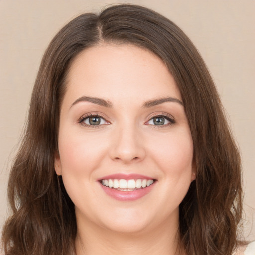 Joyful white young-adult female with long  brown hair and green eyes