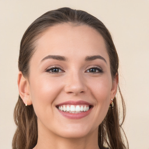 Joyful white young-adult female with long  brown hair and grey eyes