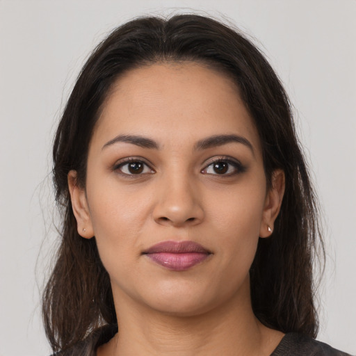 Joyful latino young-adult female with long  brown hair and brown eyes