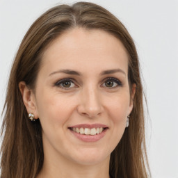 Joyful white young-adult female with long  brown hair and grey eyes