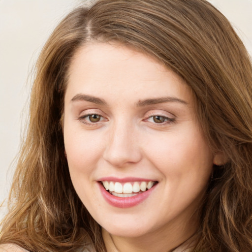 Joyful white young-adult female with long  brown hair and green eyes