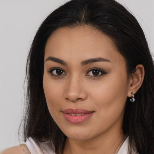 Joyful latino young-adult female with long  brown hair and brown eyes