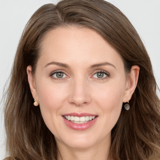 Joyful white young-adult female with long  brown hair and grey eyes